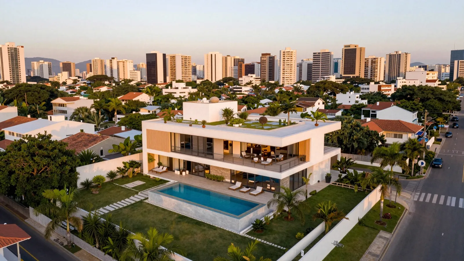 Vista aérea de residência com piscina iluminada ao entardecer